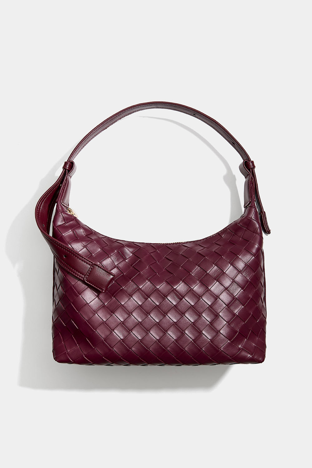 Viininpunainen käsilaukku, jossa punottu pinta