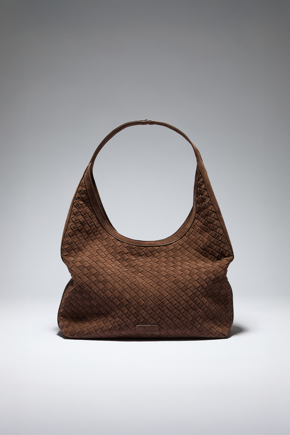 Ruskea hobo-tyylinen laukku, jossa punottu pinta