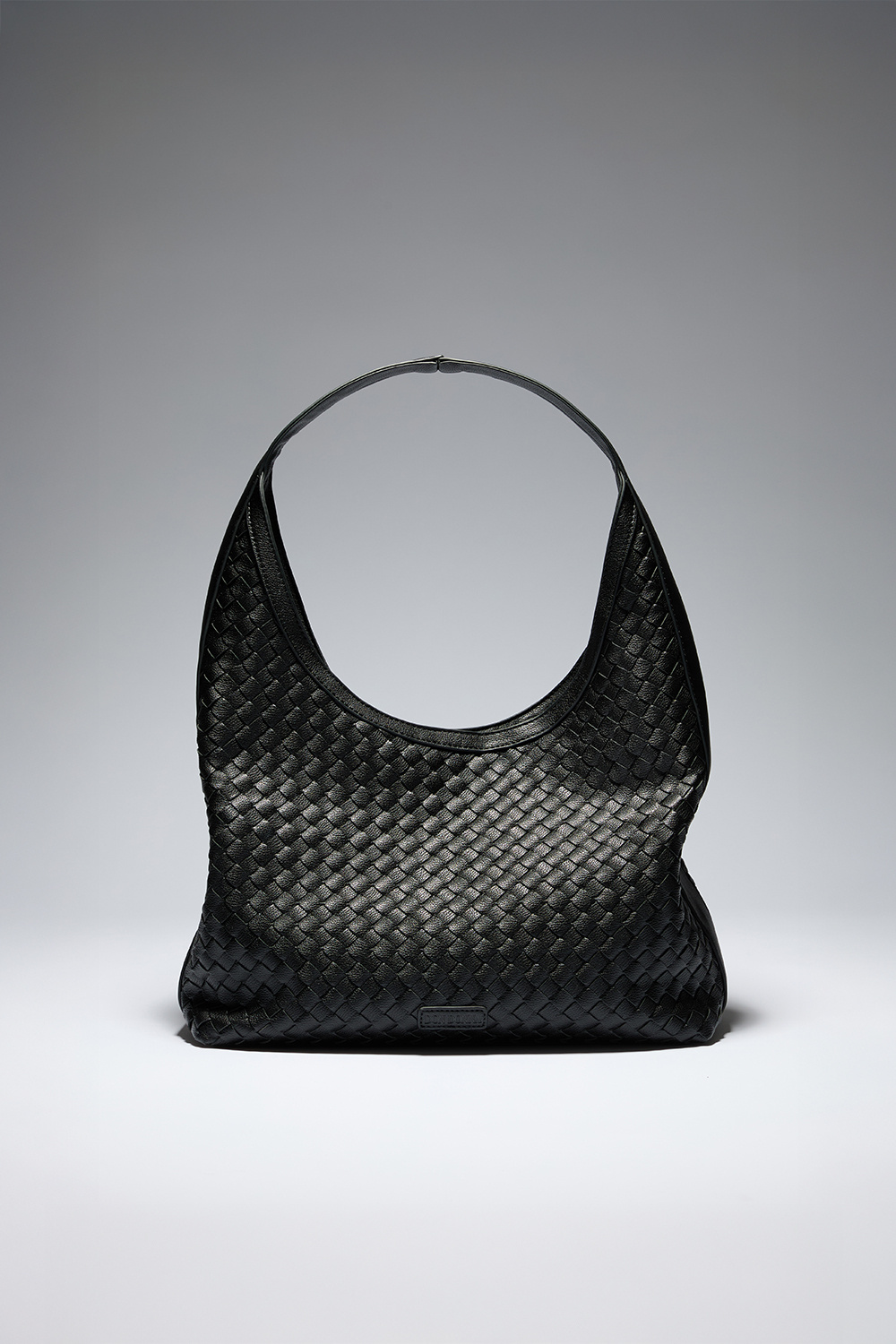 Musta hobo-tyylinen laukku, jossa punottu pinta