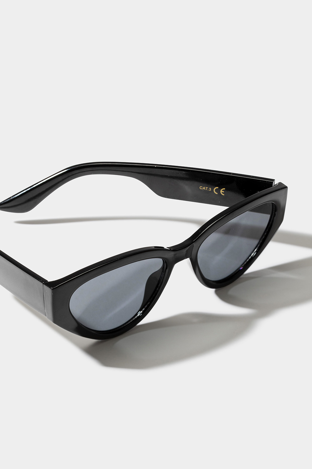 Mustat aurinkolasit, joissa pyöristetty cat eye -muotoilu