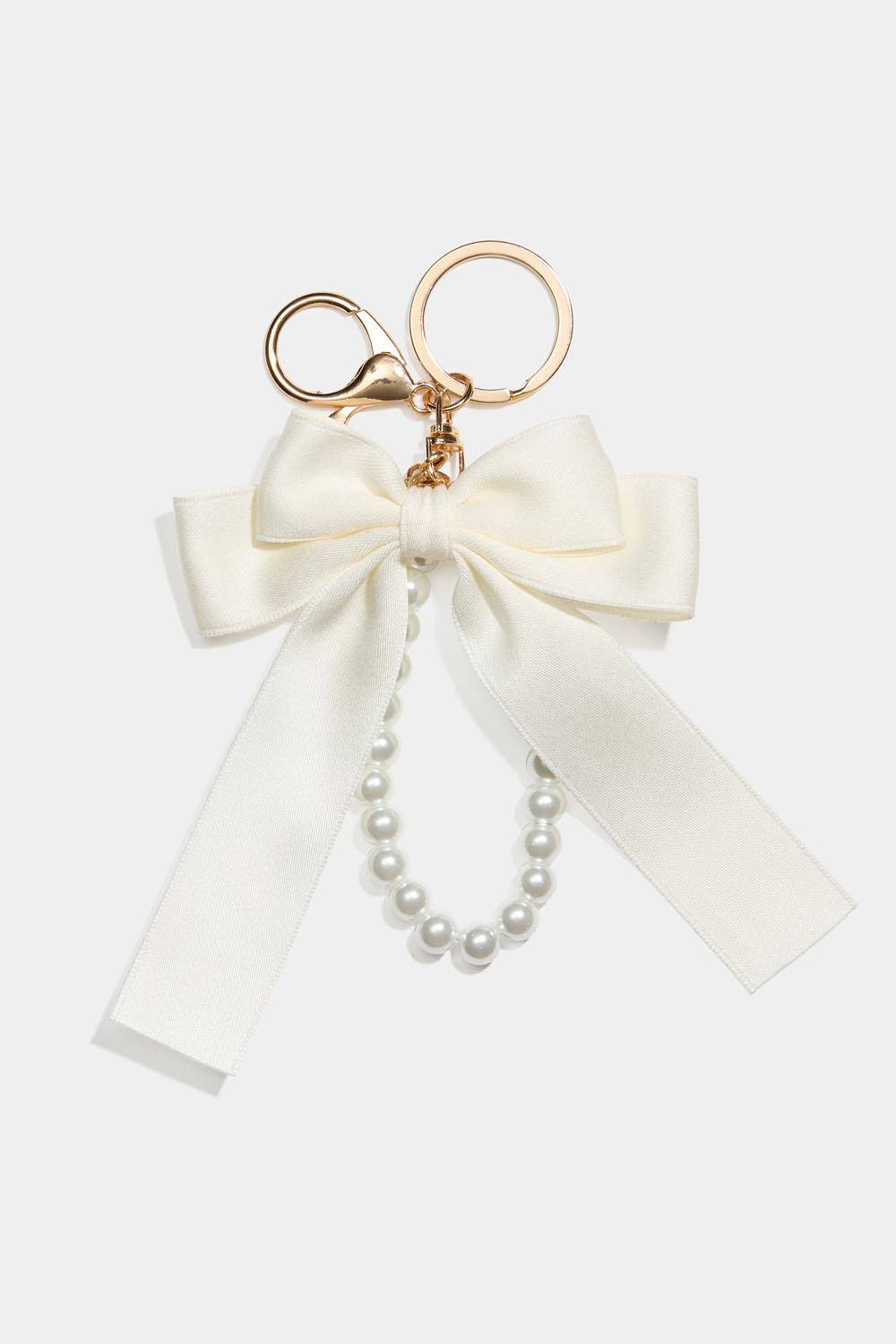 Laukkukoriste, jossa valkoinen rusetti ja helminauha