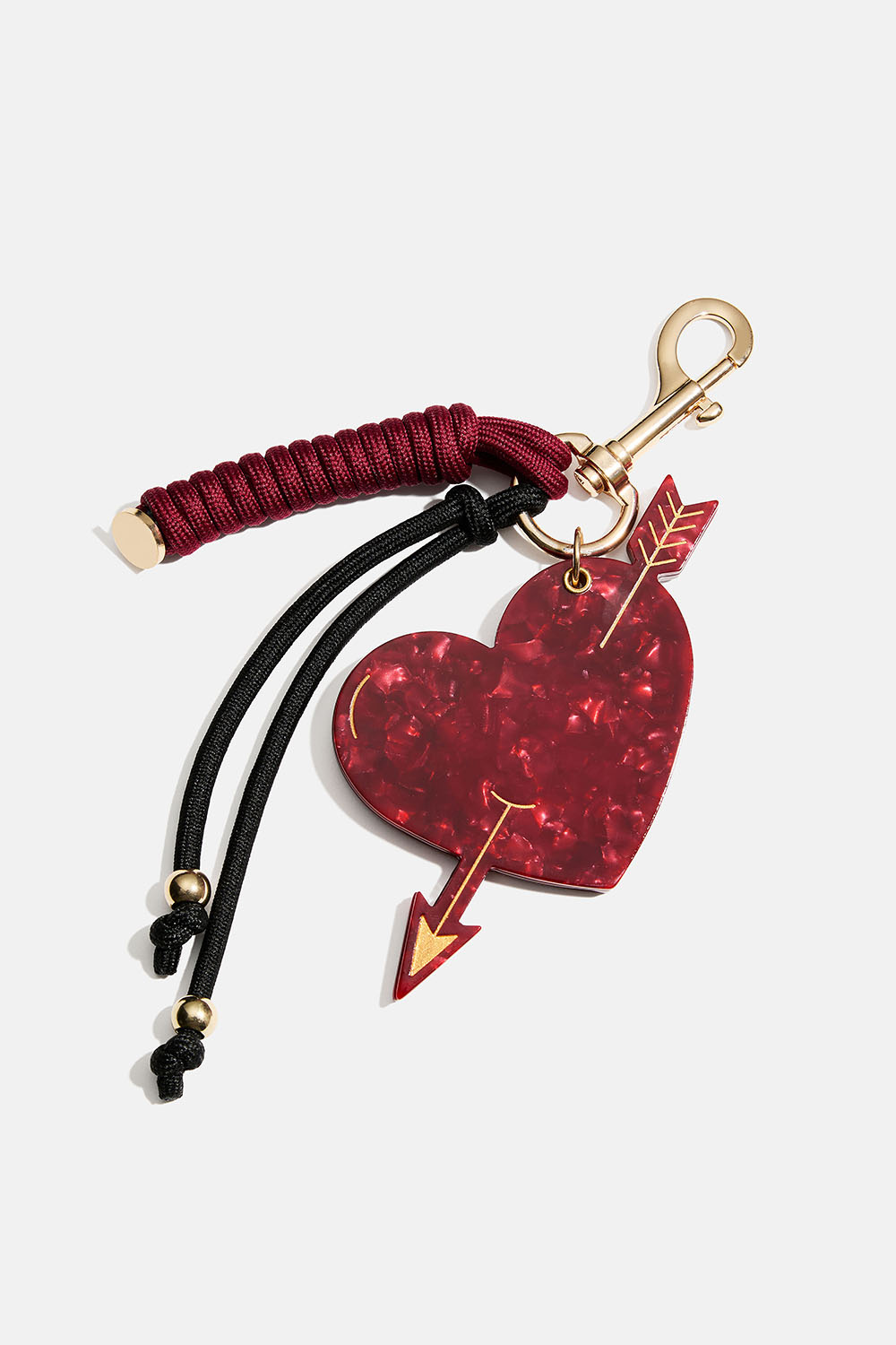 Laukkukoriste, jossa pieni peili, sydän ja naru.