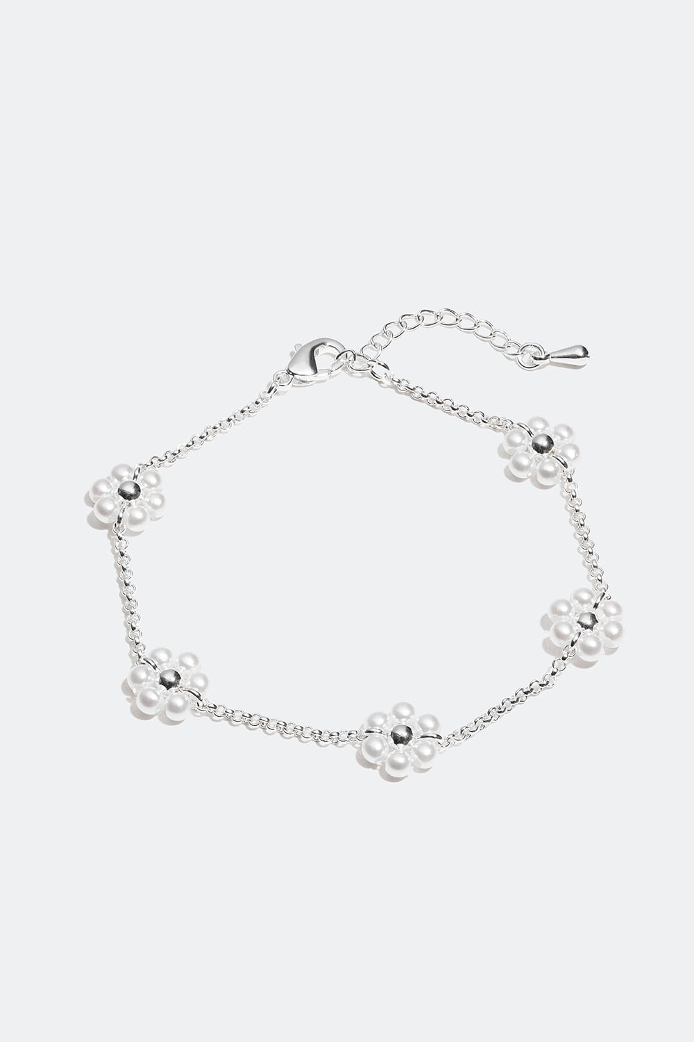 Vaaleanpunainen rannekoru, jossa on valkoisia kukkia