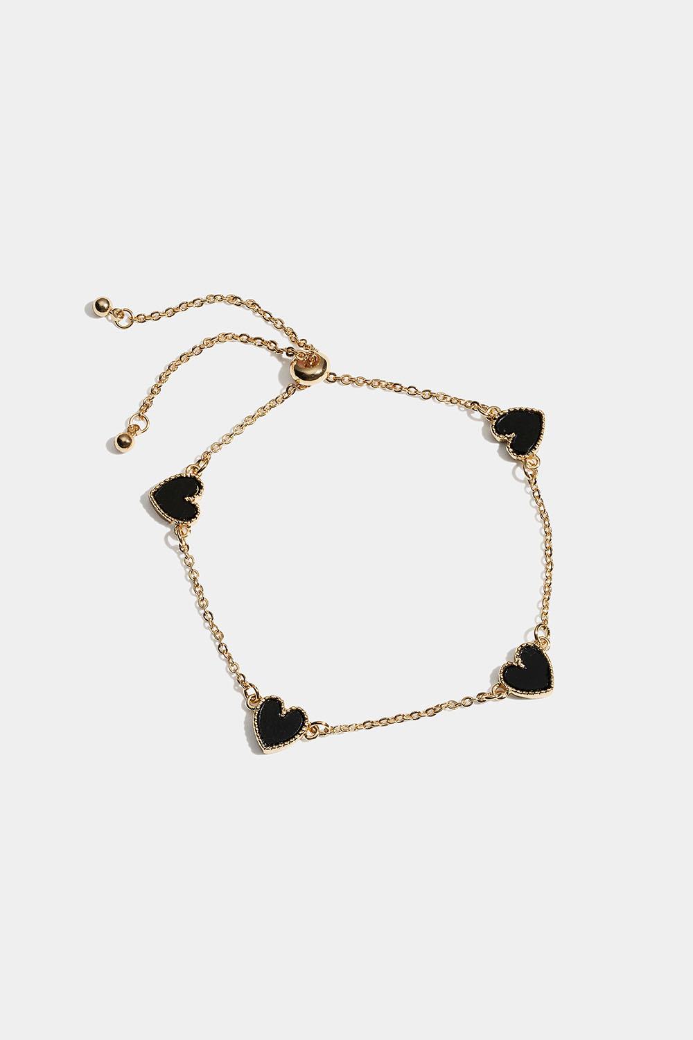 Kullanvärinen rannekoru, jossa mustia sydämiä
