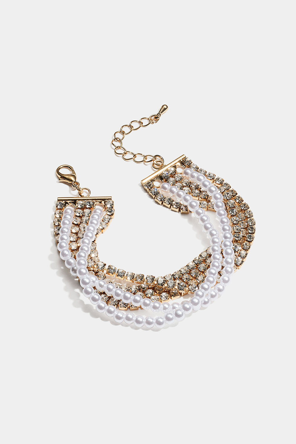 Leveä kullanvärinen rannekoru, jossa on strassi- ja helmiketjuja