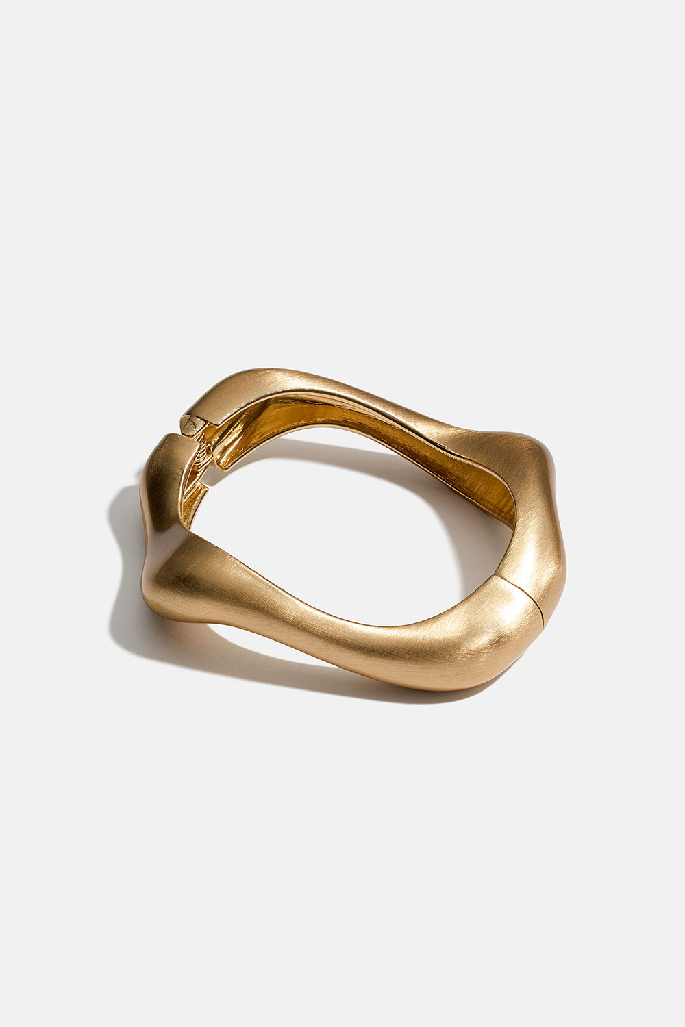 Aaltomainen ja pinnaltaan harjattu kullanvärinen rannerengas