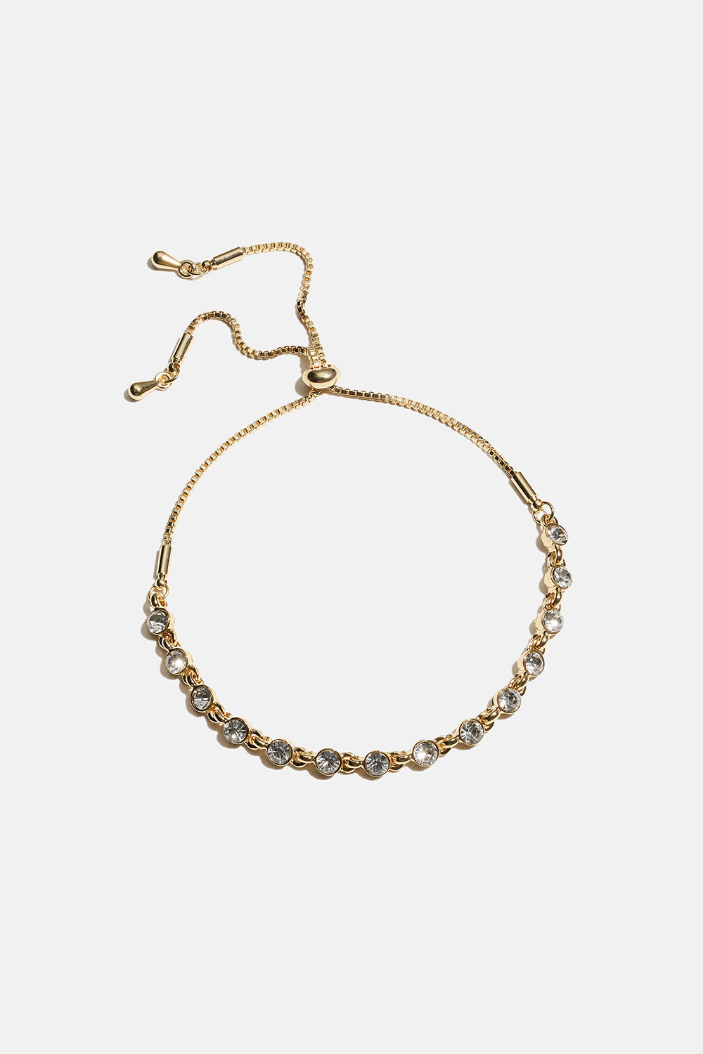 Leveä kullanvärinen rannekoru, jossa pyöreitä lasikiviä