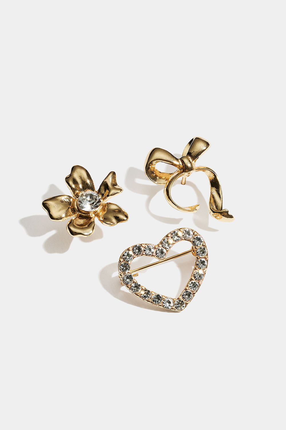 Kullanväriset rintaneulat, joissa on joko rusetti, kukka tai sydän, 3 kpl