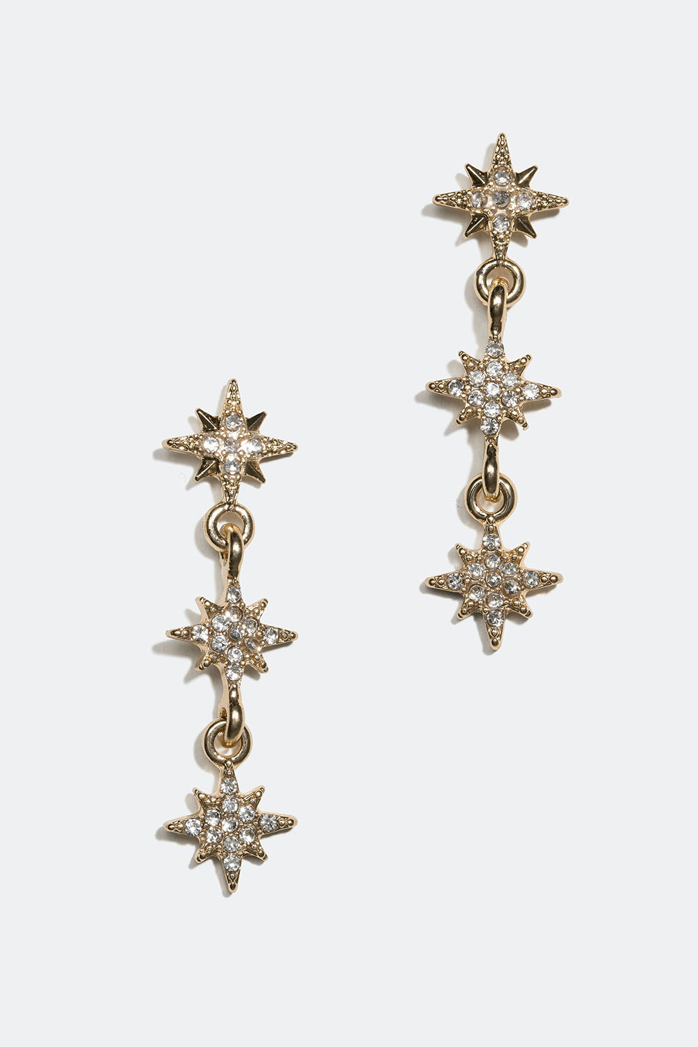Kullanväriset korvakorut, joissa on pieniä tähtiä ja lasikiviä