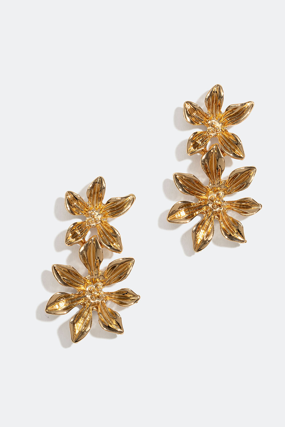 Kullanväriset korvakorut, joissa kaksi kukkaa