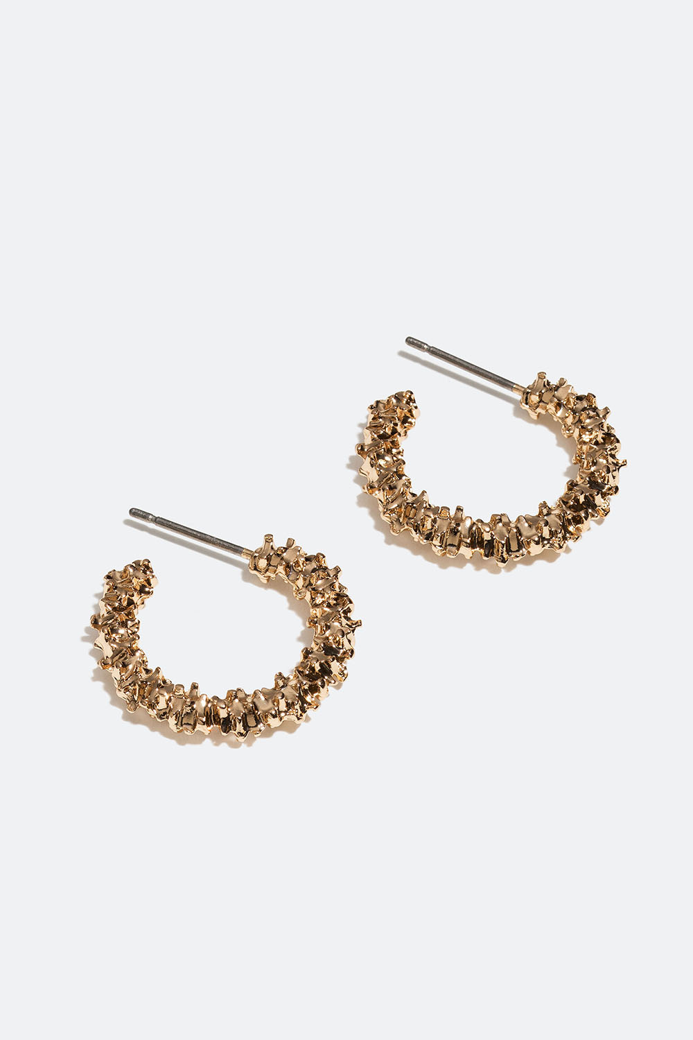 Pienet kullanväriset korvarenkaat, joissa rikottu pinta