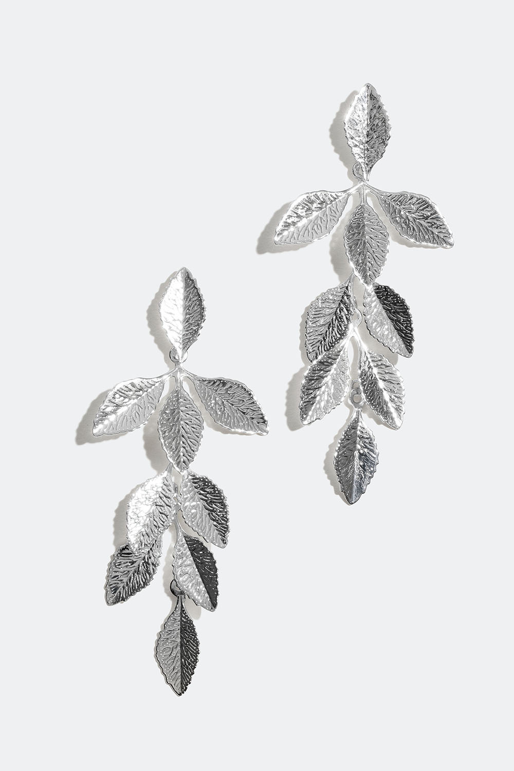 Pitkät korvakorut, joissa lehtiä