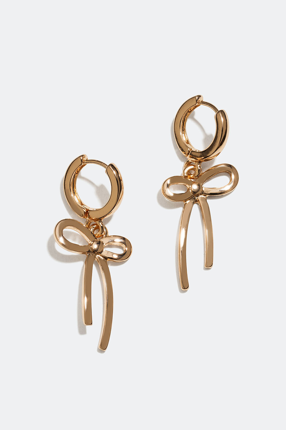 Pienet kullanväriset korvarenkaat, joissa rusetteja