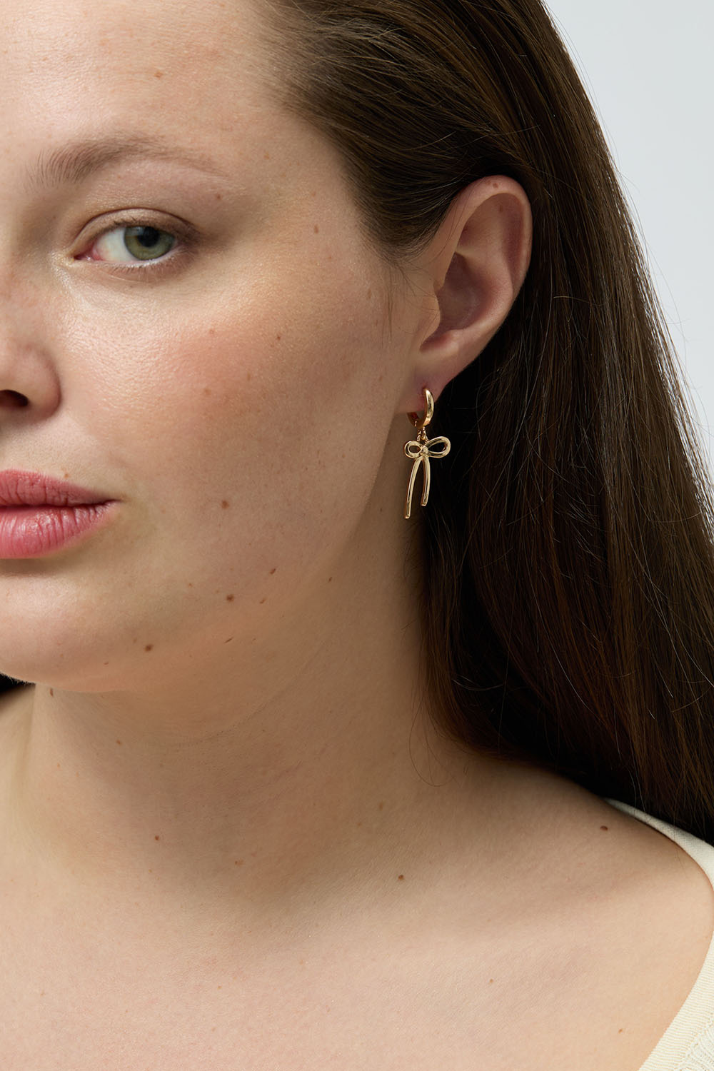 Pienet kullanväriset korvarenkaat, joissa rusetteja