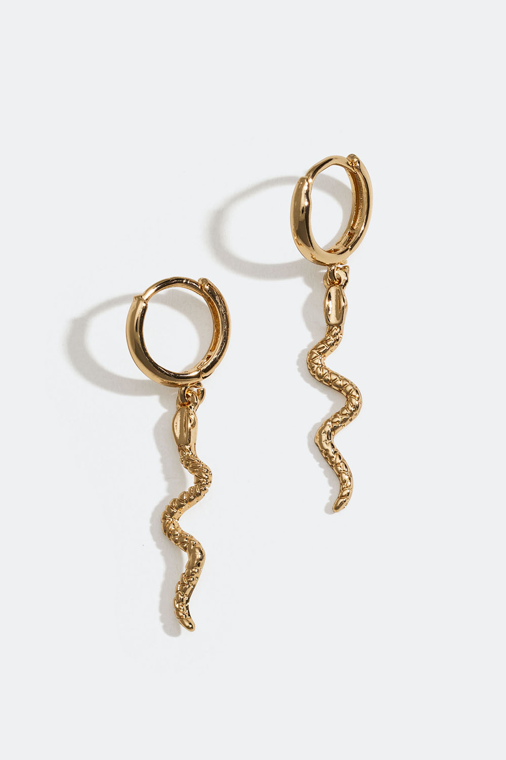 Pienet kullanväriset korvarenkaat, joissa käärmeitä