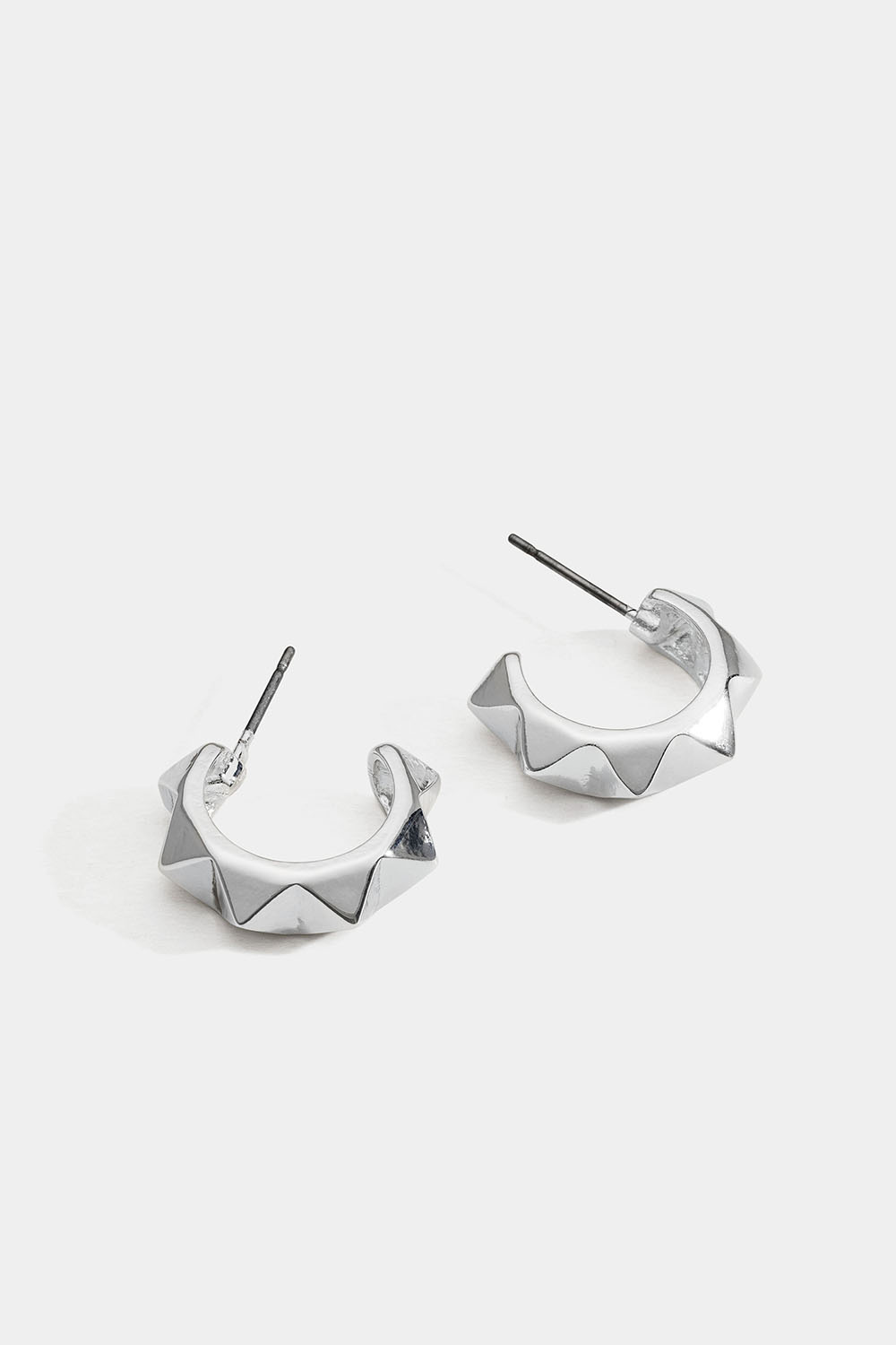 Hopeanväriset korvarenkaat, joissa niittejä