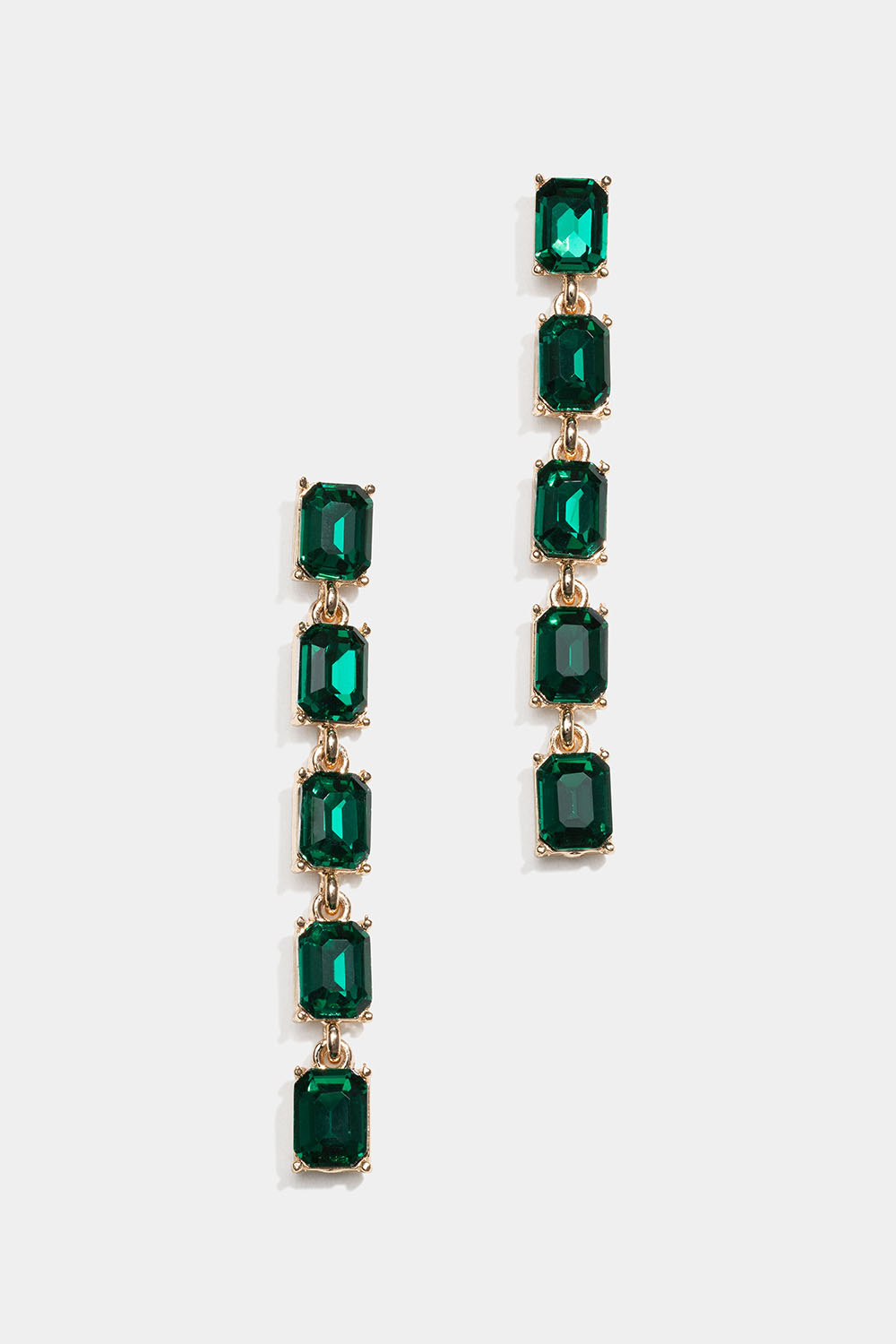 Pitkät kullanväriset korvakorut, joissa vihreitä lasikiviä