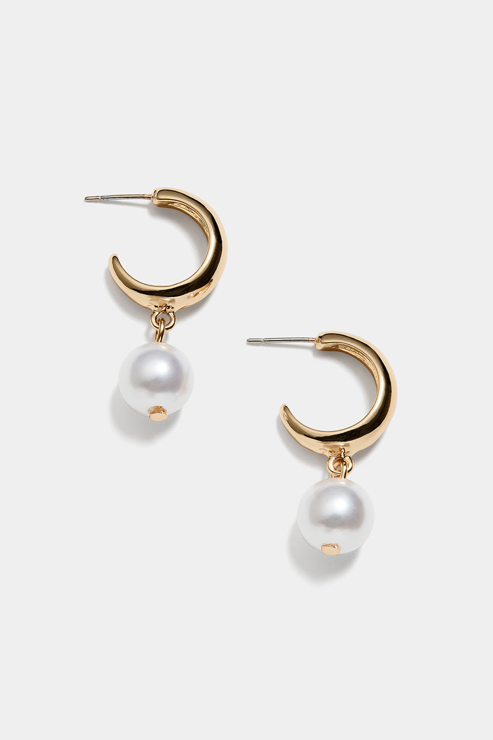 Leveät kullanväriset korvarenkaat, joissa pieniä valkoisia helmiä