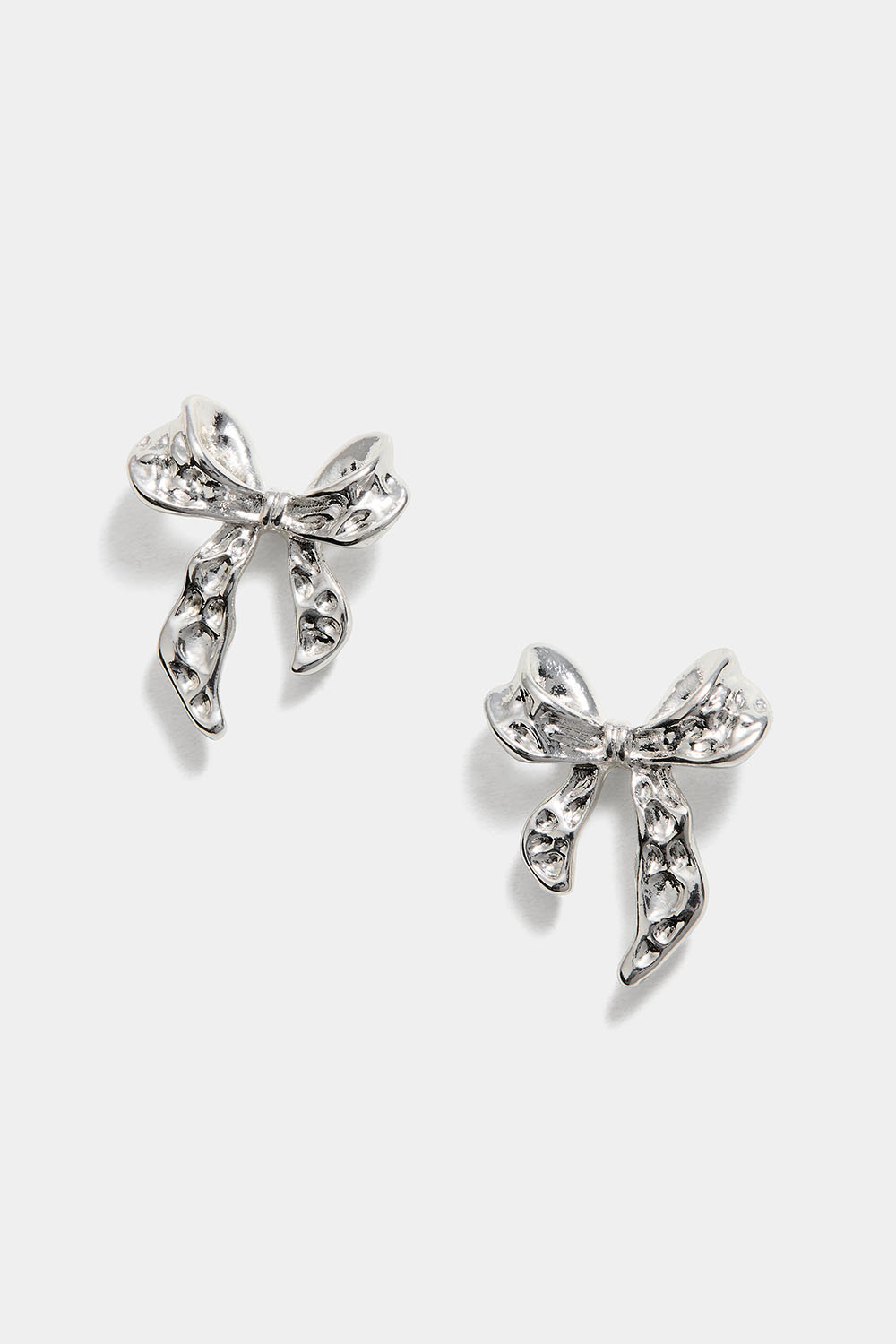 Nappikorvakorut, joissa on vasaroituja rusetteja