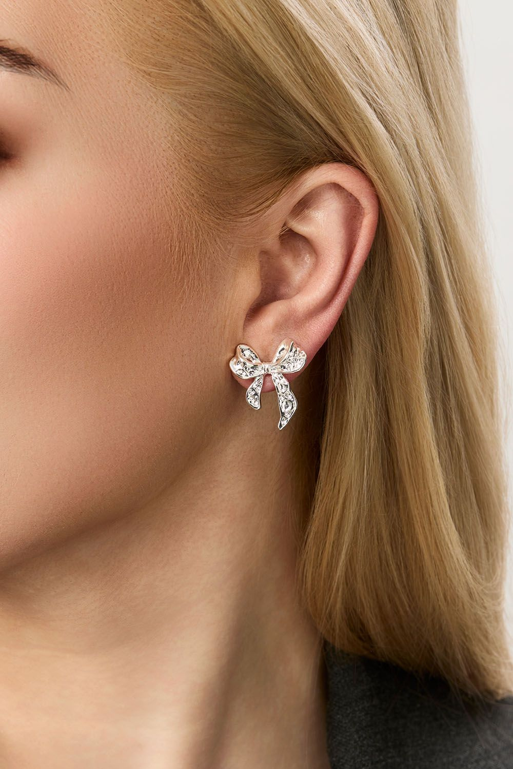 Nappikorvakorut, joissa on vasaroituja rusetteja