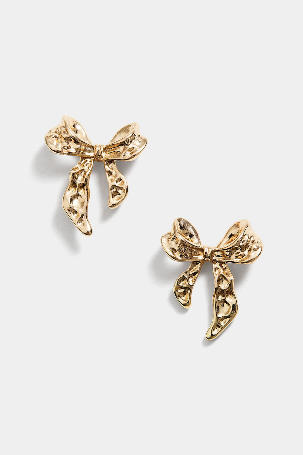 Kullanväriset nappikorvakorut, joissa on vasaroituja rusetteja