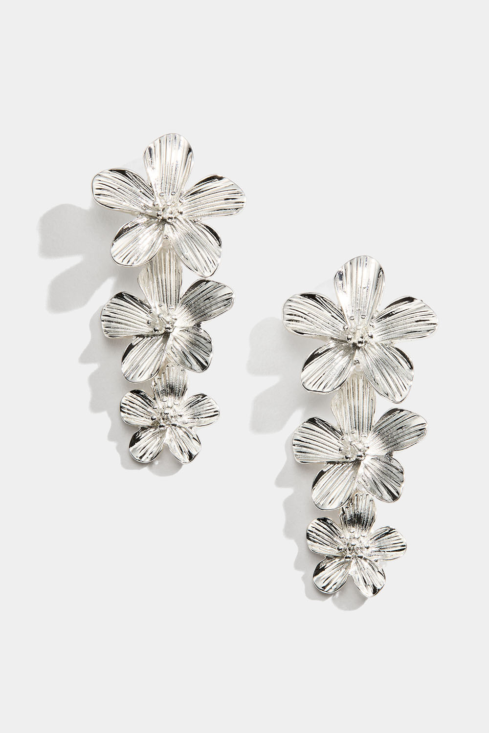 Hopeanväriset korvakorut kolmella kukalla