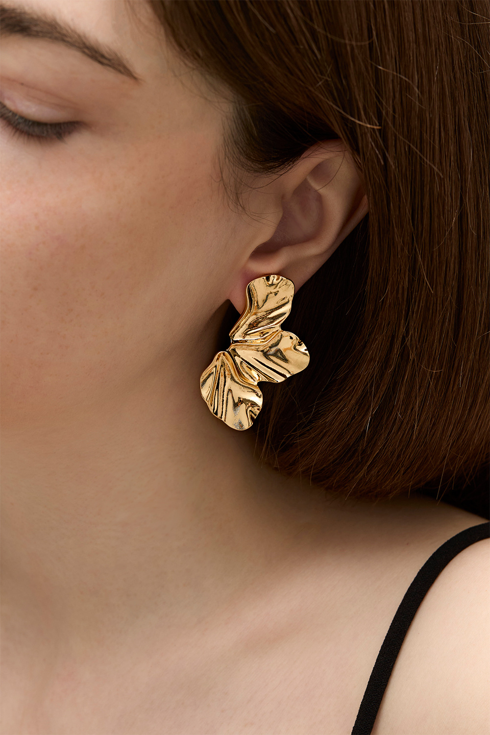 Kullanväriset korvakorut, joissa terälehtiä