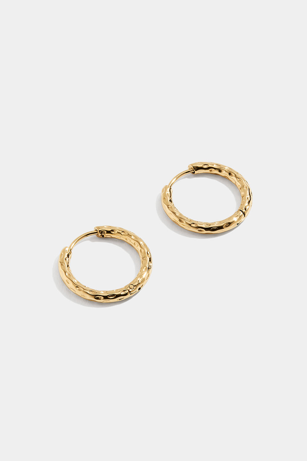 Taotut teräksiset korvarenkaat, joissa 18k kultaus