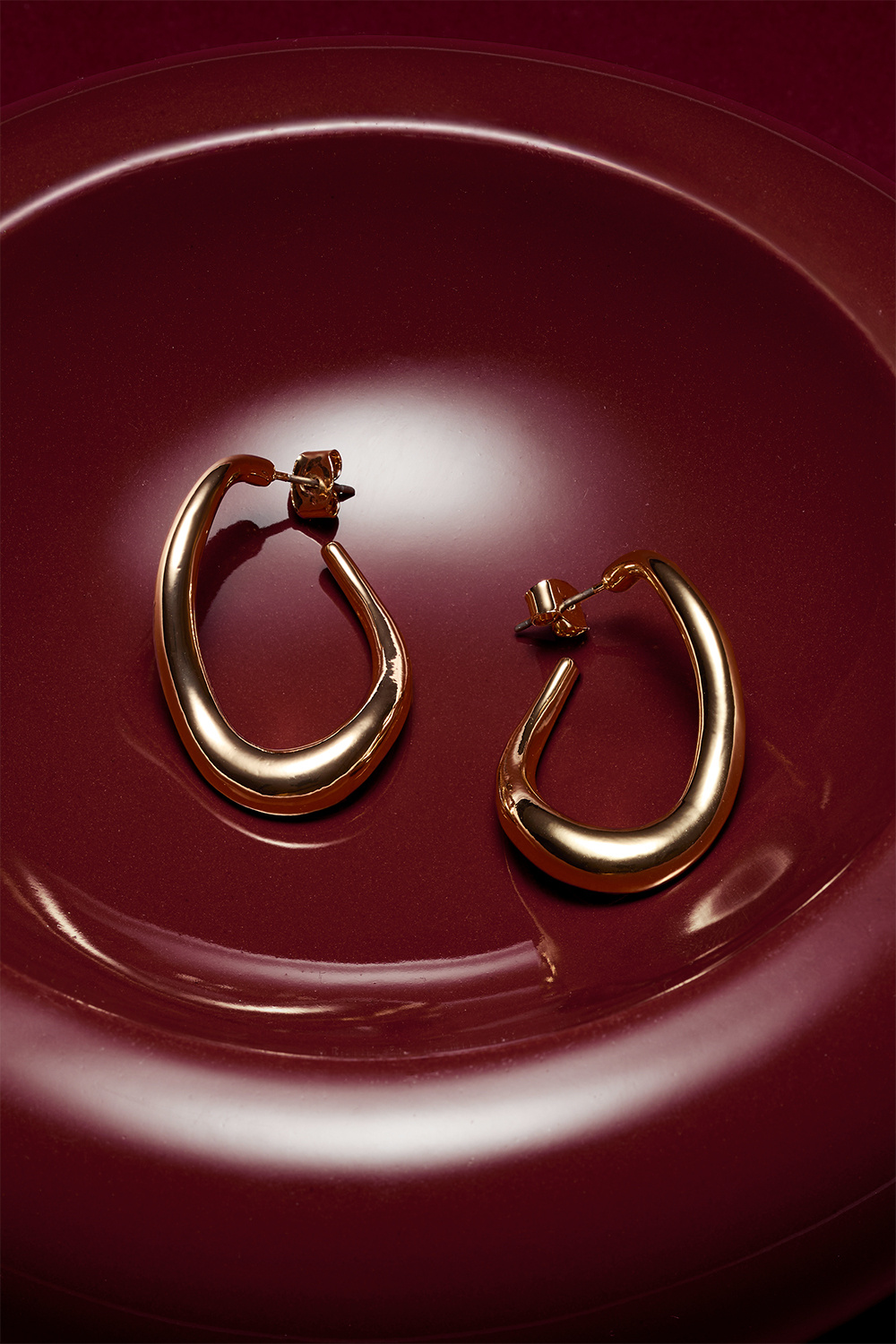 Kullanväriset korvarenkaat, joissa aaltoileva muoto