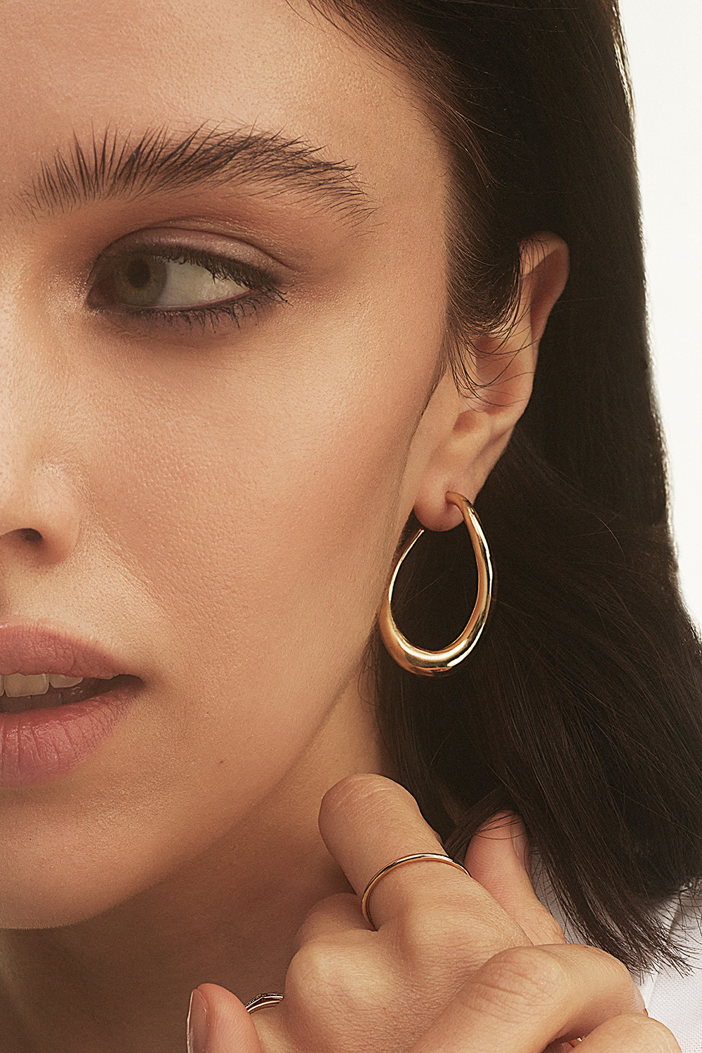 Kullanväriset korvarenkaat, joissa aaltoileva muoto