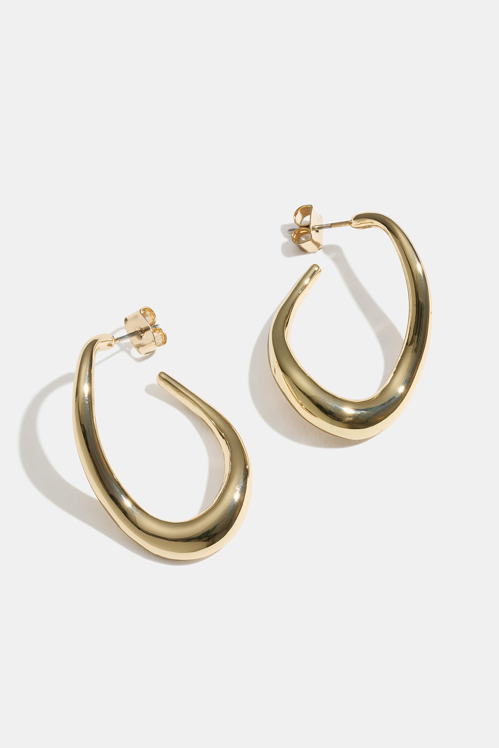 Kullanväriset korvarenkaat, joissa aaltoileva muoto