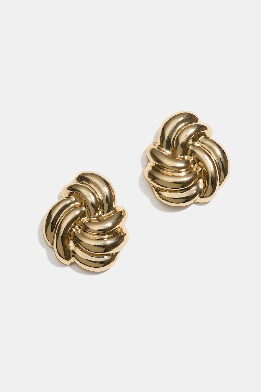 Suuret kullanväriset korvakorut, joissa solmu