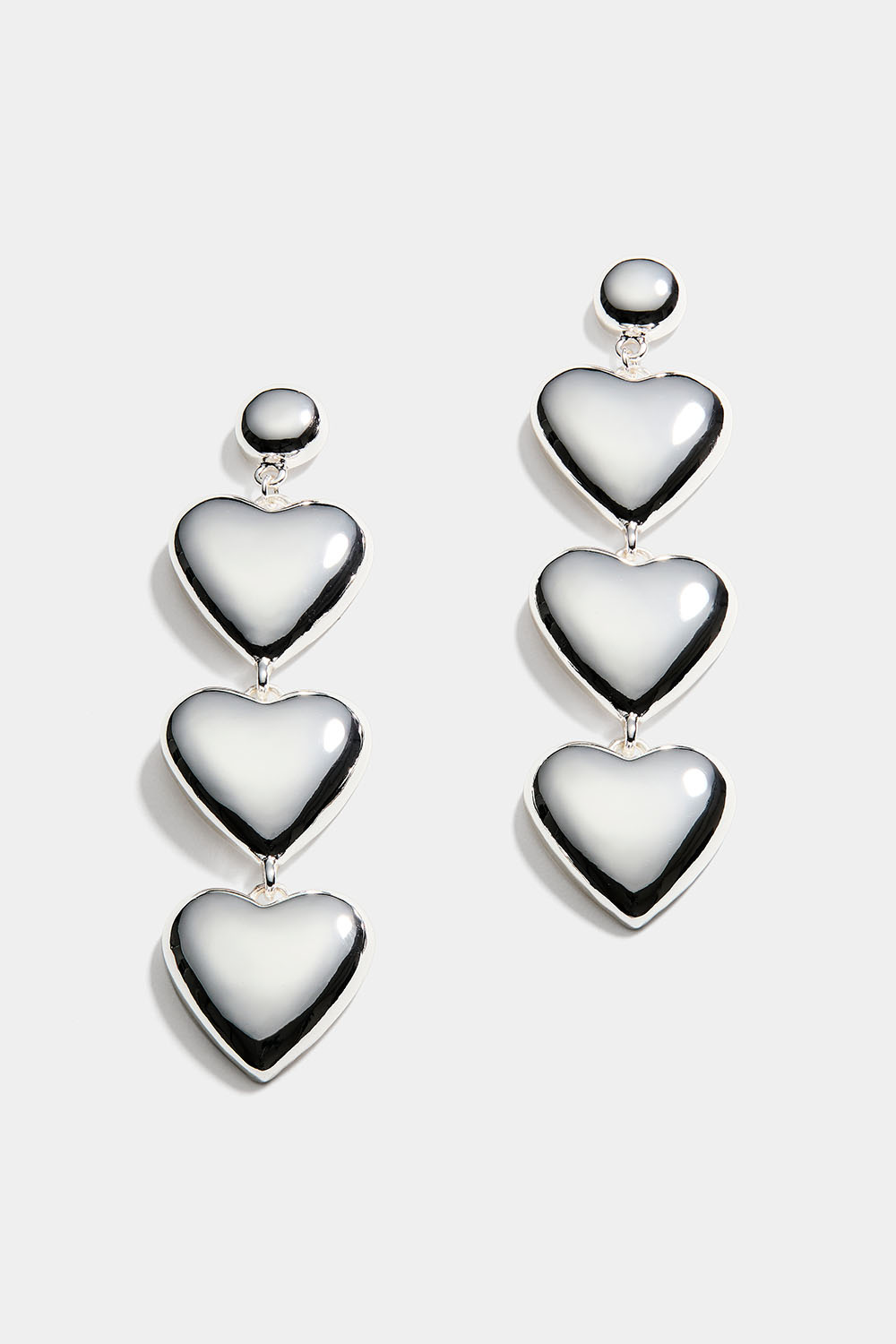 Pitkät korvakorut, joissa kolme sydäntä