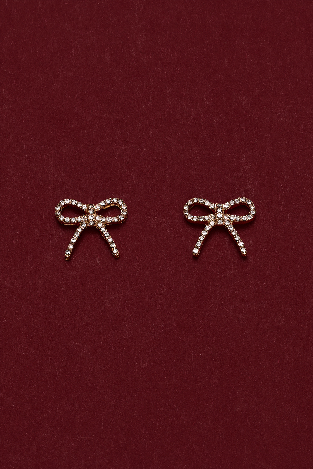 Kullanväriset rusettinappikorvakorut, joissa strasseja