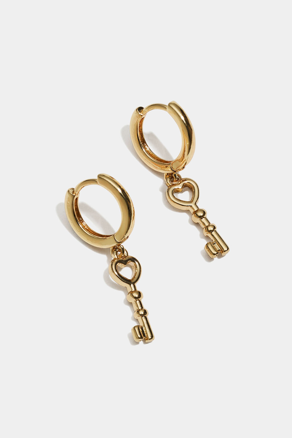 Kullanväriset korvarenkaat, joissa avainriipus