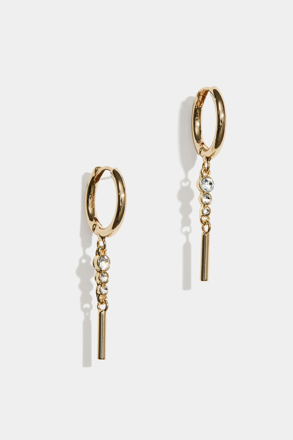 Kullanväriset korvarenkaat, joissa roikkuu strassikiviä ja sauva.