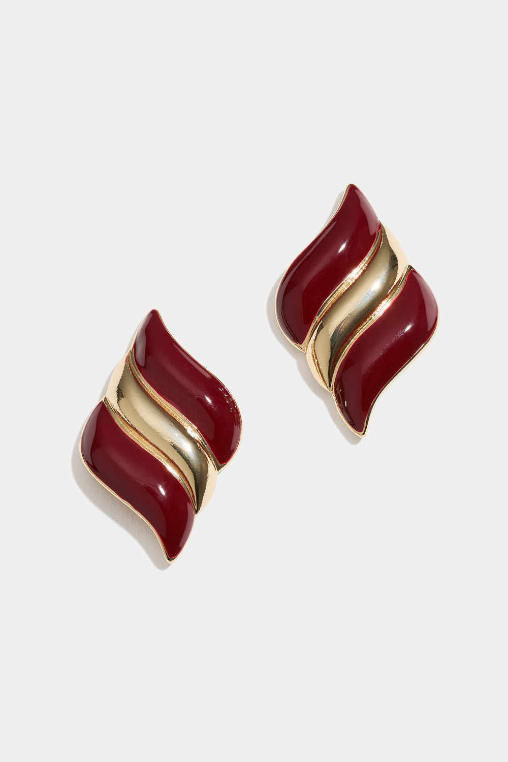 Viininpunaiset nappikorvakorut aaltoilevalla muotoilulla