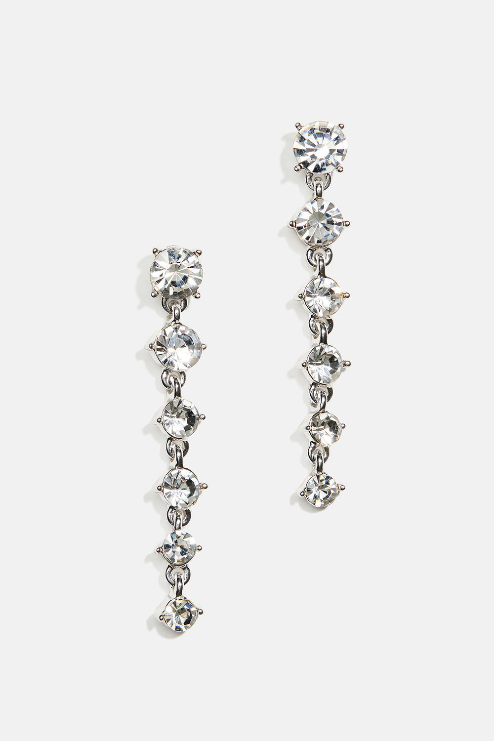 Korvakorut valkoisilla pyöreillä lasikivillä