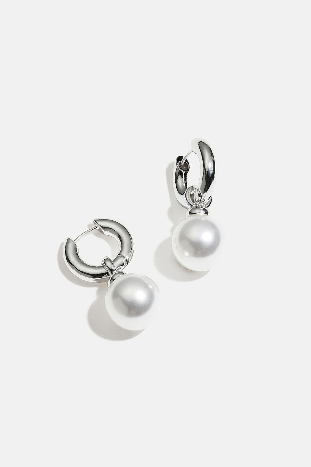 Paksut korvarenkaat, joissa on iso pyöreä helmi