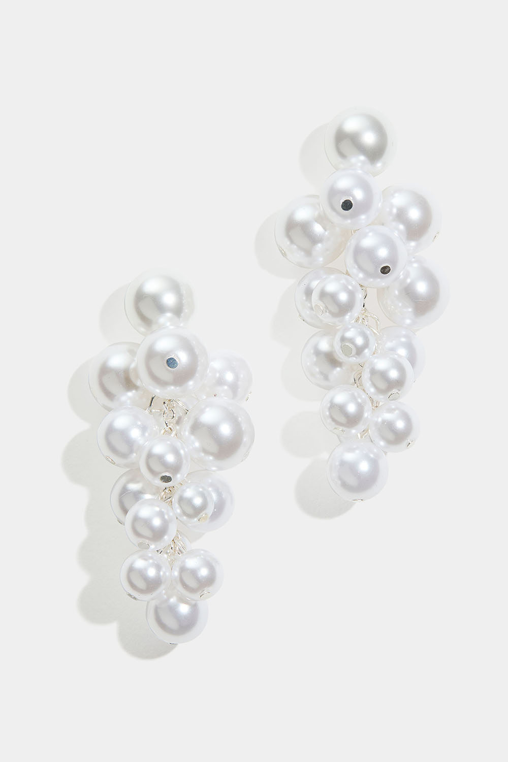 Suuret korvakorut, joissa on valkoisia helmiä