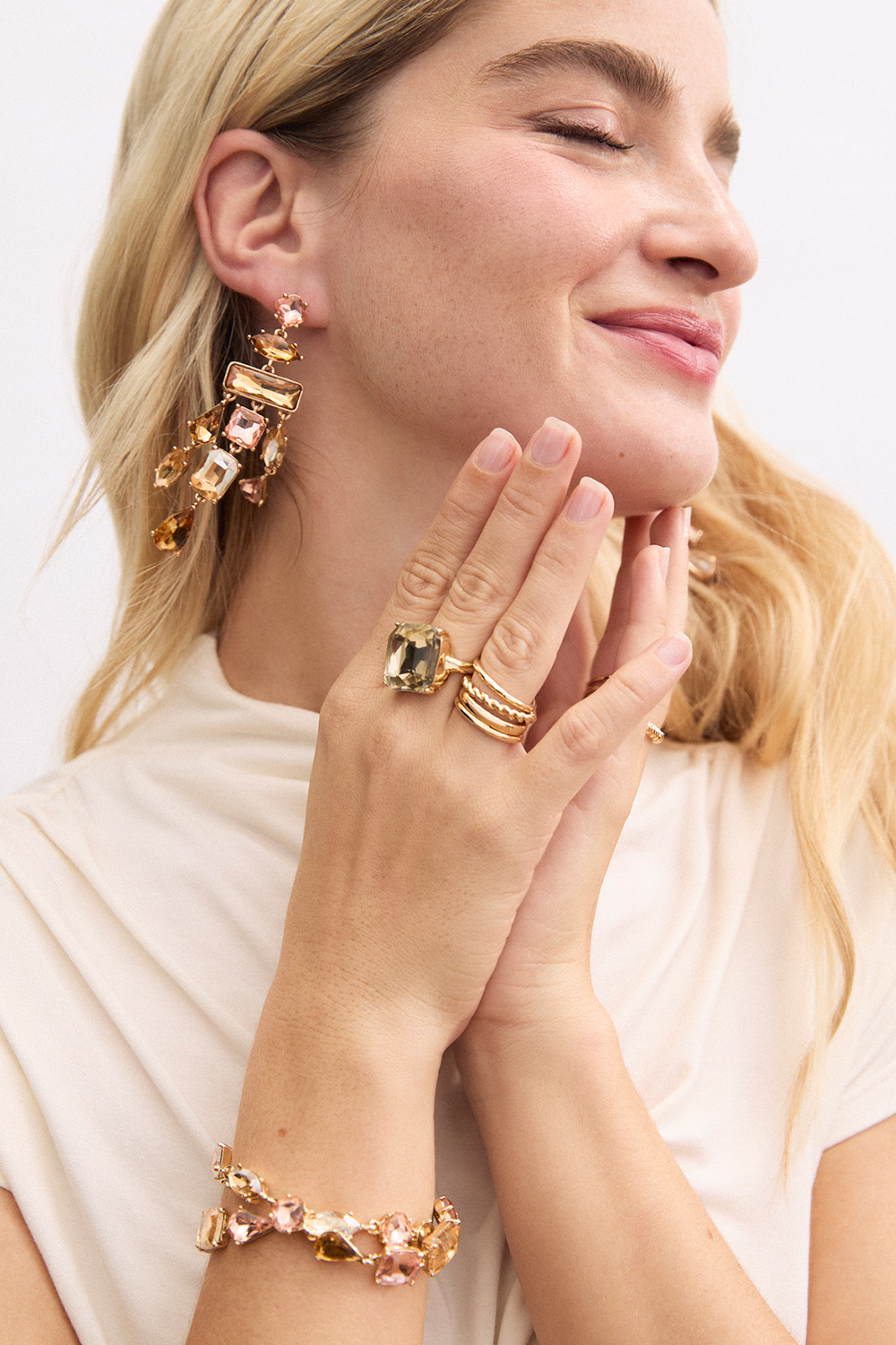 Isot korvakorut, joissa on erimuotoisia vaaleanpunaisia ja beigejä lasikiviä