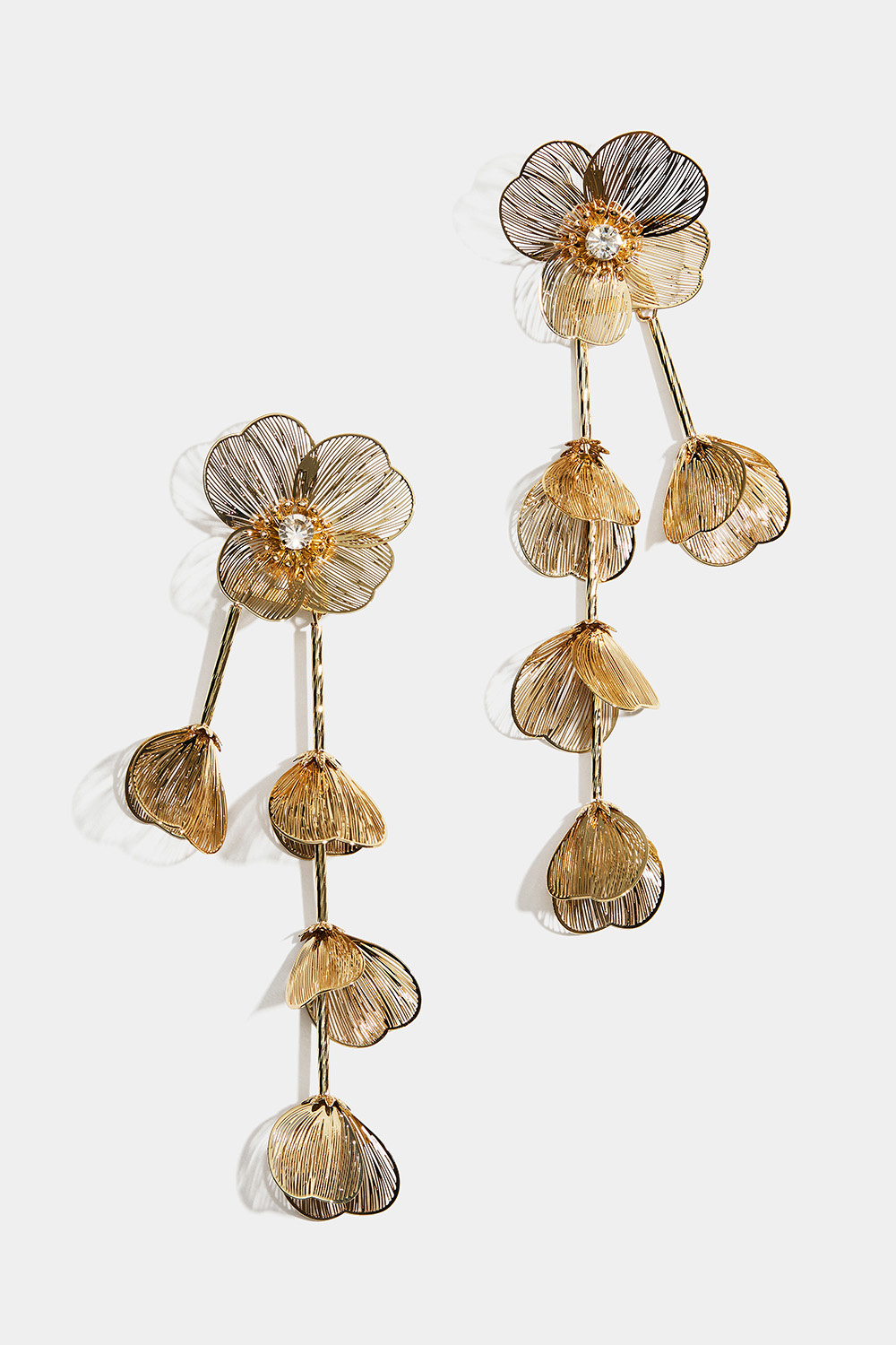 Suuret kullanväriset korvakorut, joissa kukkia ja riippuvia terälehtiä