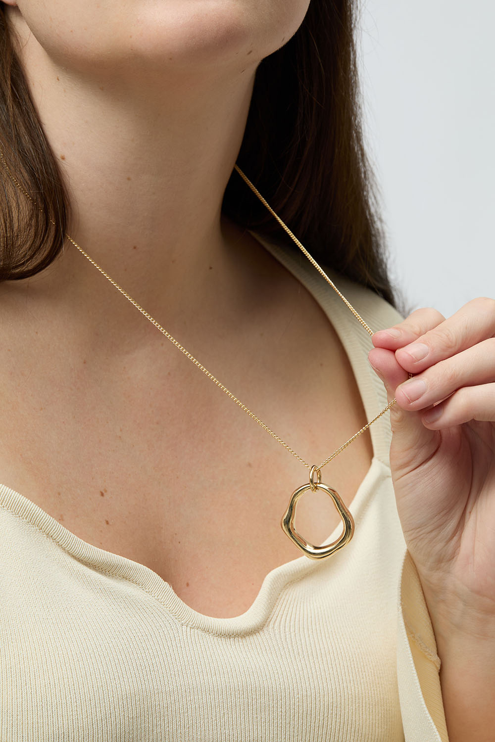 Kullanvärinen kaulakoru, jossa orgaanisen muotoinen riipus