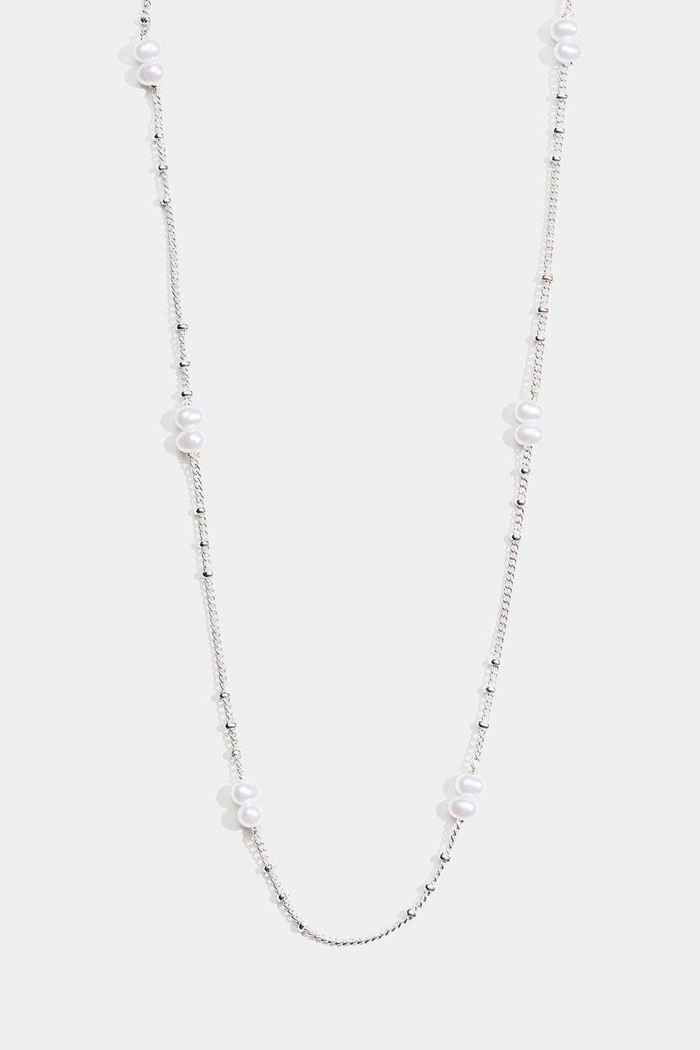 Ohut kaulakoru, jossa on soikeita valkoisia helmiä