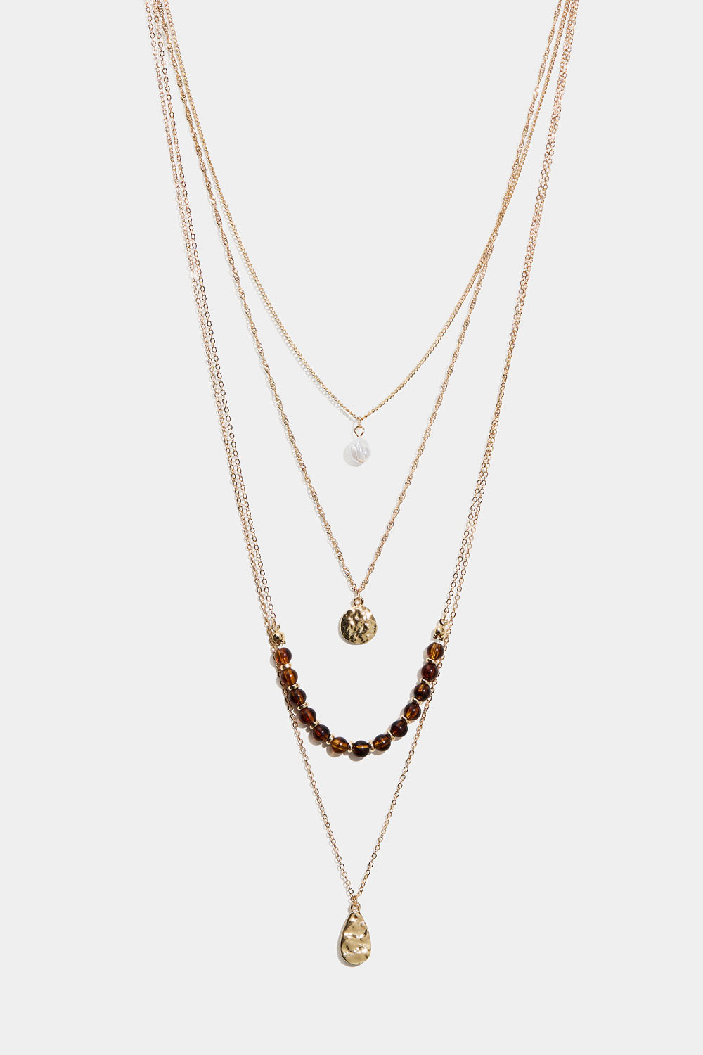 Pitkä kaulakoru, jossa on neljä ketjua ja riipuksia