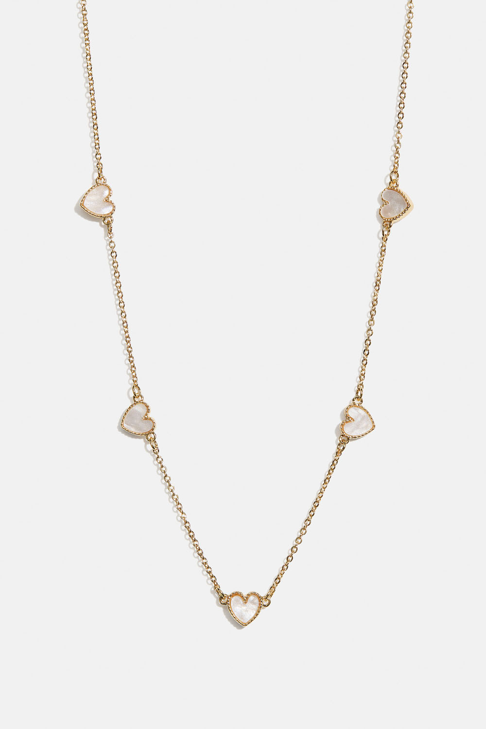 Kullanvärinen kaulakoru, jossa valkoisia sydämiä