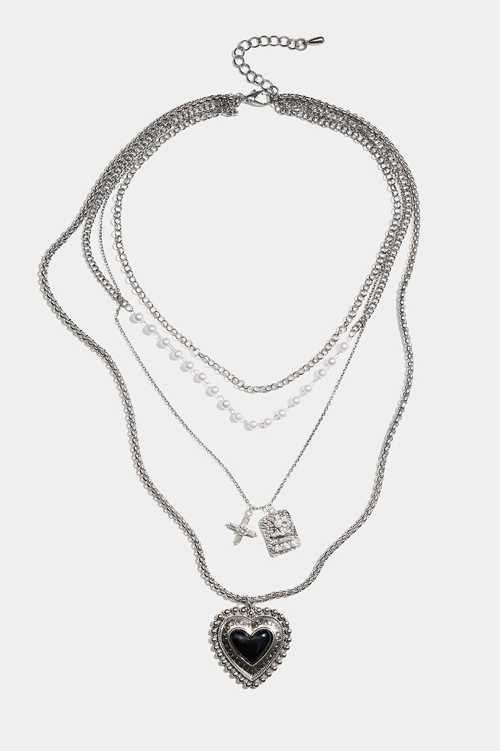 Pitkä kaulakoru, jossa on sydän ja erilaisia ketjuja.