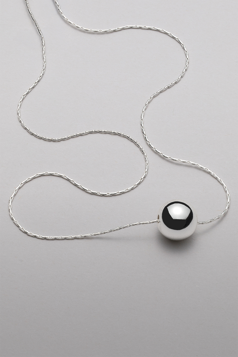 Kaulakoru, jossa pyöreä ketju ja hopeainen helmi