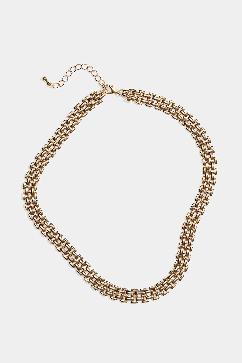 Leveä kullanvärinen rannekoru, jossa tiivis ketju