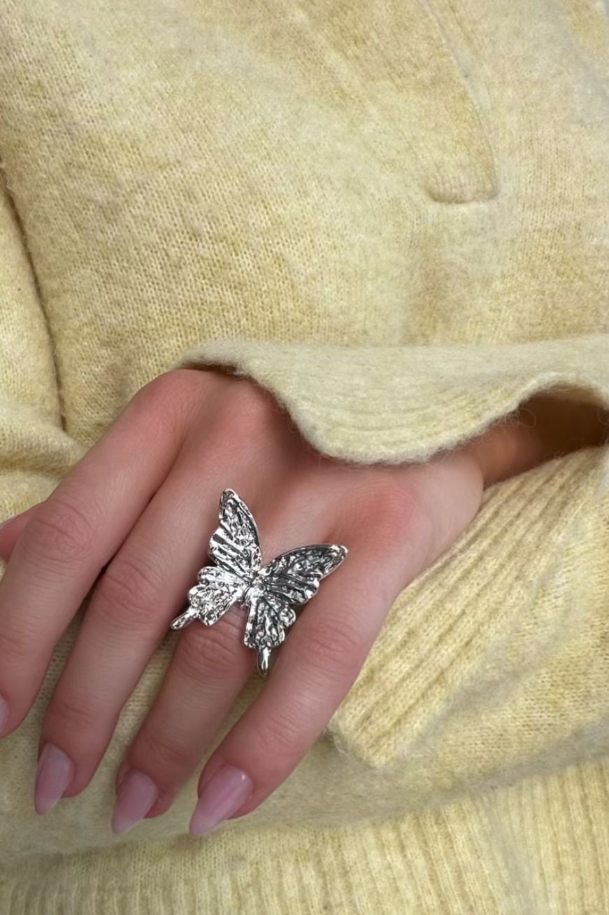 Sormus, jossa perhonen ja vasaroitu muotoilu